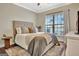 Bedroom with a neutral color scheme, large window, and a decorative rug under the bed at 609 Francis Ave, Peachtree City, GA 30269