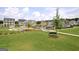 Aerial view of a lush green lawn, bench, and community pool lined with tables, chairs, and lounge chairs at 609 Francis Ave, Peachtree City, GA 30269