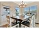 Sunlit dining room featuring a rustic wood table, modern chandelier, and access to outdoor space at 609 Francis Ave, Peachtree City, GA 30269