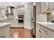 Well-lit kitchen featuring stainless steel appliances, white cabinetry and wood flooring at 609 Francis Ave, Peachtree City, GA 30269