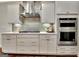 Modern kitchen with white cabinets, stainless appliances, and stylish backsplash at 609 Francis Ave, Peachtree City, GA 30269