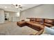 Spacious living room featuring a large leather sectional sofa, carpeted floors, and a ceiling fan at 609 Francis Ave, Peachtree City, GA 30269