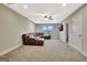 Cozy living room with brown leather sectional couch, plush carpet, and mounted TV at 609 Francis Ave, Peachtree City, GA 30269