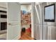 Open pantry with shelves stocked with food and supplies next to stainless steel refrigerator at 609 Francis Ave, Peachtree City, GA 30269