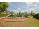 Community playground with climbing structures, a slide, a mulch ground cover, and several townhomes in the background at 609 Francis Ave, Peachtree City, GA 30269