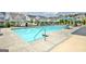 Community pool with umbrellas, lounge chairs and tables with chairs, and several townhomes in the background at 609 Francis Ave, Peachtree City, GA 30269
