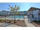 Community pool surrounded by wrought-iron fencing and bordered by a mulch bed with landscaping, a tree and community homes at 609 Francis Ave, Peachtree City, GA 30269