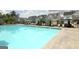 Community pool with umbrellas, lounge chairs and tables with chairs, and several townhomes in the background at 609 Francis Ave, Peachtree City, GA 30269