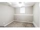 Finished basement area with neutral carpet, small window, and ceiling fan at 149 Camden Woods Pl, Dallas, GA 30157