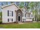 A charming two-story home showcases a stone entryway and black shutters for a classic look at 149 Camden Woods Pl, Dallas, GA 30157