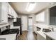 The well-lit kitchen features white cabinets, stainless steel appliances, and an efficient layout for cooking at 149 Camden Woods Pl, Dallas, GA 30157