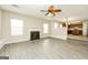 Bright living room with fireplace, modern ceiling fan, and stylish floors leading to the kitchen at 3675 Arminto Dr, Ellenwood, GA 30294