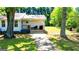A cozy front porch invites visitors with its brick pathway, seating, and classic design and a neatly kept lawn at 20 Rosser Rd, Mcdonough, GA 30252
