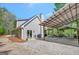 Grey home featuring a covered outdoor seating area, lush trees, a grill, and gravel driveway at 40 Butler Bridge Dr, Mcdonough, GA 30252