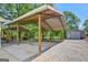 Home's unique structure with open, covered steel and wood beams, garage, and gravel yard blend seamlessly at 40 Butler Bridge Dr, Mcdonough, GA 30252