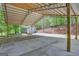 Expansive concrete pad and gravel driveway under a covered steel structure with wood support beams at 40 Butler Bridge Dr, Mcdonough, GA 30252