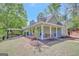 Inviting single-Gathering home boasting a spacious front porch with swing, surrounded by manicured landscaping and mature trees at 40 Butler Bridge Dr, Mcdonough, GA 30252