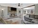 Cozy living room featuring a stone fireplace, ceiling fan, and an open view to the dining area at 40 Butler Bridge Dr, Mcdonough, GA 30252