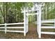 A white fence surrounds a backyard with a white pergola, perfect for gardening or relaxing at 173 Darwish Dr, Mcdonough, GA 30252