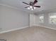 Bright bedroom boasts neutral carpet, a ceiling fan, and natural light from windows at 173 Darwish Dr, Mcdonough, GA 30252
