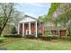 Traditional red brick home boasts a symmetrical facade with white columns and well-manicured landscaping at 173 Darwish Dr, Mcdonough, GA 30252