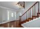 Inviting foyer featuring hardwood floors, elegant chandelier, and a staircase with decorative trim at 173 Darwish Dr, Mcdonough, GA 30252