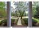 View of the front yard through the pillars, showcasing a mature dogwood tree at 173 Darwish Dr, Mcdonough, GA 30252