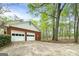 The exterior of a two-car garage with white doors and an expansive driveway at 173 Darwish Dr, Mcdonough, GA 30252