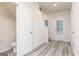 Well-lit hallway with gray vinyl floors, white walls, and multiple white doors at 295 Limestone Circle, Conyers, GA 30013