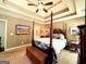 Comfortable bedroom featuring a trey ceiling and four poster bed at 108 Stonecrest Dr, Carrollton, GA 30116