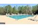 Outdoor community swimming pool surrounded by lounge chairs and mature trees at 108 Stonecrest Dr, Carrollton, GA 30116