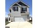 Two-story home featuring a two-car garage and modern gray siding with contrasting black shutters and trim at 458 Prescott Way, Villa Rica, GA 30180