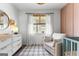 Bright Bedroom featuring a crib, glider, natural light, and a unique accent wall at 217 Christina Ct, Peachtree City, GA 30269