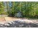 Backyard shed surrounded by a white picket fence and lush trees at 217 Christina Ct, Peachtree City, GA 30269