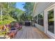 Outdoor deck with a grill, chairs, and lush green surroundings, perfect for relaxing and entertaining at 203 Silverwood Way, Peachtree City, GA 30269