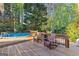 Back deck with a pool, seating, and lush greenery creates a serene outdoor oasis at 203 Silverwood Way, Peachtree City, GA 30269