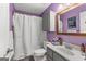 Updated bathroom with vanity and shower combination with purple walls and white trim at 203 Silverwood Way, Peachtree City, GA 30269