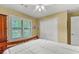View of a bright bedroom with a large window, white trim and wood furniture at 203 Silverwood Way, Peachtree City, GA 30269