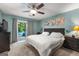Beautiful bedroom with a gray tufted headboard, ceiling fan, and sliding glass door to the outside at 203 Silverwood Way, Peachtree City, GA 30269
