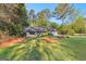 Beautiful home surrounded by lush greenery and mature trees on a sunny day at 203 Silverwood Way, Peachtree City, GA 30269