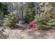 A stone pathway passes through beautifully landscaped shrubs and flowers in the yard at 203 Silverwood Way, Peachtree City, GA 30269