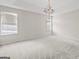 Spacious carpeted bedroom with chandelier and plenty of natural light from two windows at 2550 Columbia Crossing Ct, Decatur, GA 30034