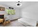 Minimalist bedroom featuring a large window with tree views, neutral carpet, and ample natural light at 608 E Banks Rd, Fayetteville, GA 30214