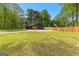 Modern dark exterior home with a spacious lawn, long driveway, and a classic wood fence at 608 E Banks Rd, Fayetteville, GA 30214