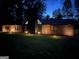 Exterior home view at night illuminated with landscape lighting and a stone and wood facade at 608 E Banks Rd, Fayetteville, GA 30214