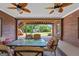 Covered back porch with wood ceiling, brick walls and seating overlooking the backyard at 103 Wisteria Way, Stockbridge, GA 30281