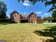 Wide shot of the backyard with mature trees, a deck, patio, and well maintained lawn at 103 Wisteria Way, Stockbridge, GA 30281