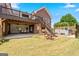 Expansive backyard with brick patio, hot tub, deck, and staircase leading to the upper level at 103 Wisteria Way, Stockbridge, GA 30281