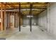 An unfinished basement with exposed ceiling, concrete floor, wooden frame and visible pipes at 103 Wisteria Way, Stockbridge, GA 30281