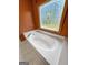Close up of the bathroom soaking tub with jets under a unique stained glass window at 103 Wisteria Way, Stockbridge, GA 30281